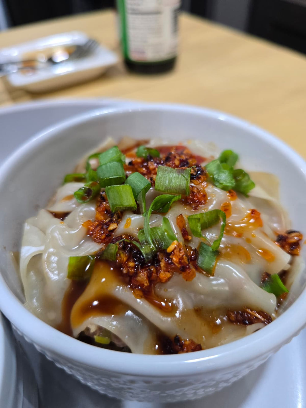 Dumpling lasagna served in a white mug with chopsticks